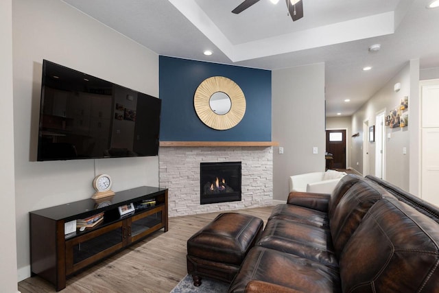 living area with ceiling fan, a stone fireplace, wood finished floors, and recessed lighting