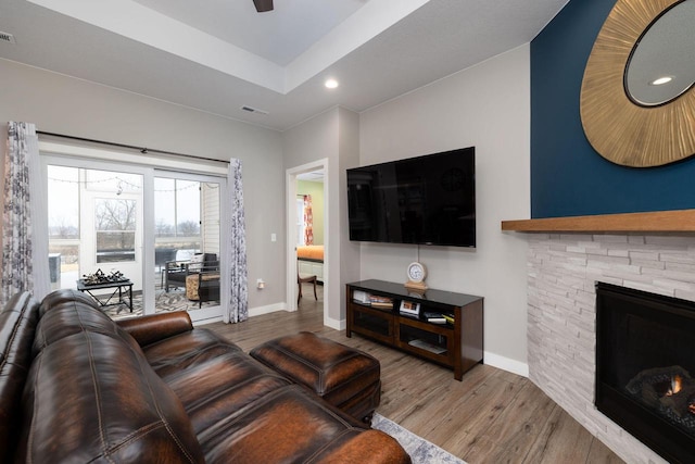 living area with a fireplace, baseboards, wood finished floors, and recessed lighting