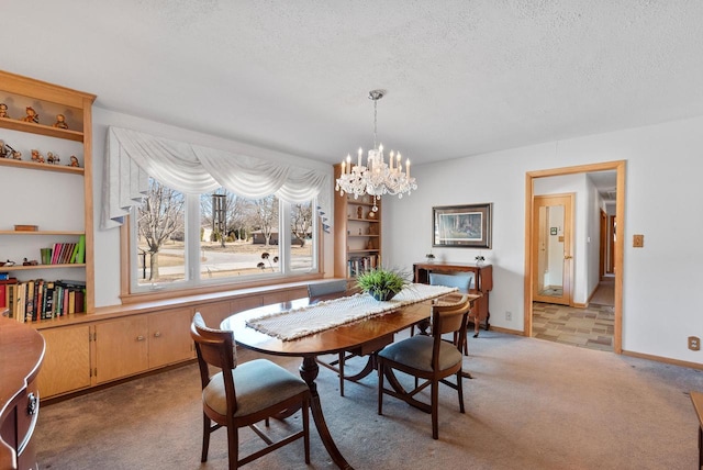 dining space featuring a textured ceiling, baseboards, a chandelier, and light carpet