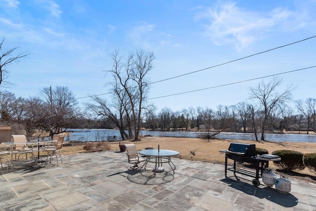 view of patio featuring a water view and outdoor dining space