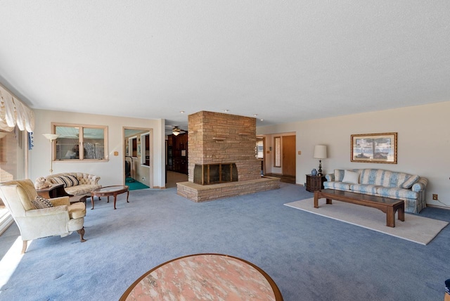 living room featuring a textured ceiling, a large fireplace, a ceiling fan, and carpet floors