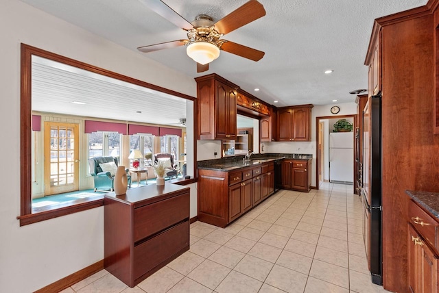 kitchen with light tile patterned floors, a sink, freestanding refrigerator, and fridge