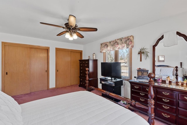 carpeted bedroom with multiple closets and a ceiling fan