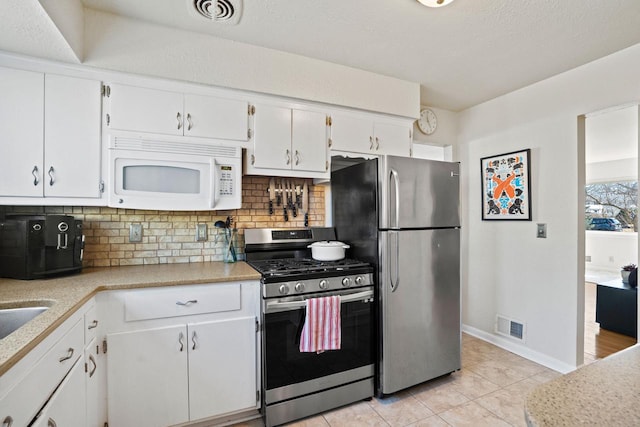 kitchen featuring white cabinetry, visible vents, backsplash, and stainless steel appliances