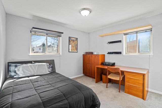 bedroom with baseboards and light carpet