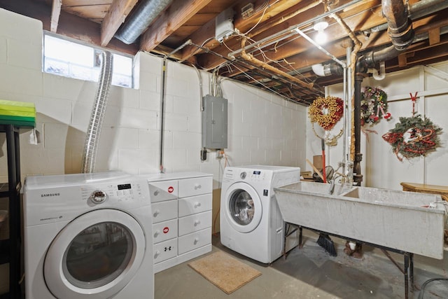 clothes washing area with washer and dryer, electric panel, laundry area, and a sink