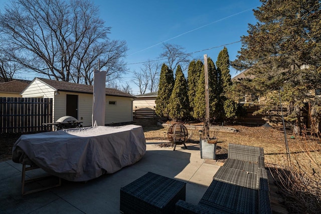 view of patio / terrace featuring an outdoor fire pit, a grill, an outdoor structure, and fence