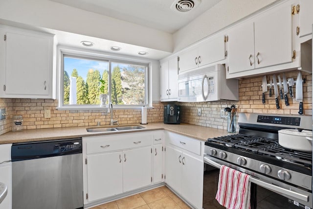 kitchen with visible vents, light countertops, light tile patterned floors, appliances with stainless steel finishes, and a sink