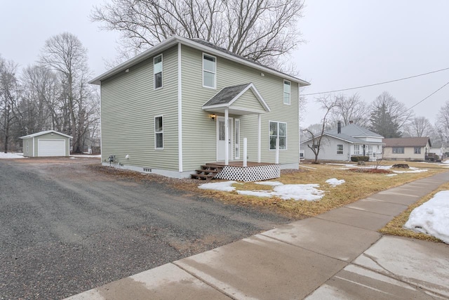 view of front facade with a garage, an outbuilding, and driveway