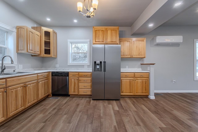 kitchen featuring dishwasher, light countertops, an AC wall unit, stainless steel refrigerator with ice dispenser, and a sink