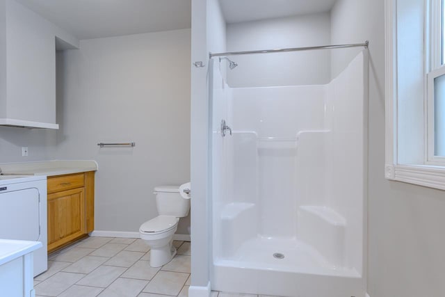 bathroom with toilet, vanity, a shower, tile patterned floors, and washer / dryer