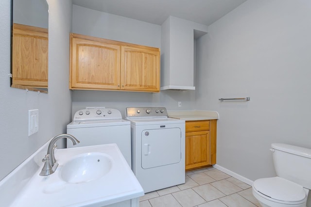 laundry area featuring laundry area, light tile patterned floors, baseboards, washing machine and dryer, and a sink