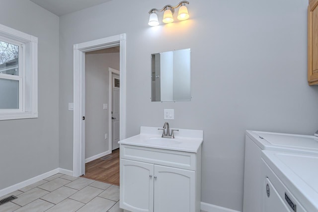 bathroom featuring washing machine and dryer, visible vents, vanity, and baseboards