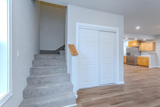 stairway with recessed lighting, baseboards, and wood finished floors