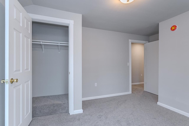 unfurnished bedroom with a closet, carpet flooring, and baseboards