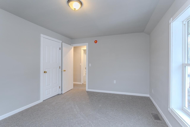 carpeted empty room featuring visible vents and baseboards