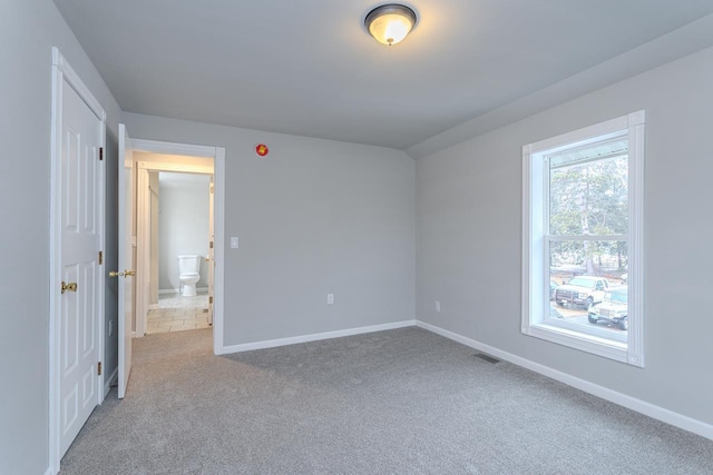 spare room with baseboards, visible vents, and carpet flooring