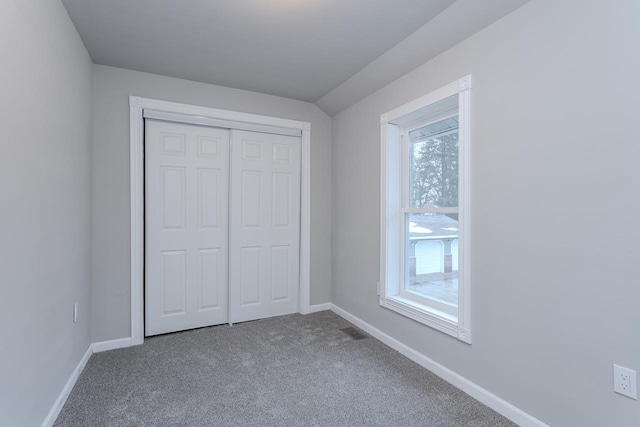 unfurnished bedroom featuring a closet, baseboards, and carpet flooring