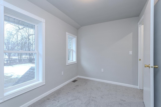 carpeted empty room featuring baseboards, visible vents, and a wealth of natural light