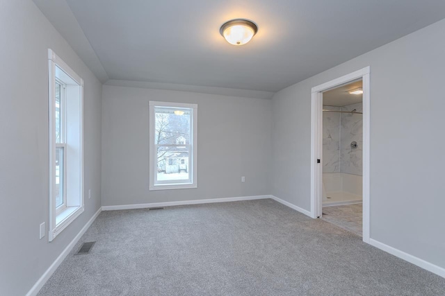 empty room with carpet floors, baseboards, and visible vents