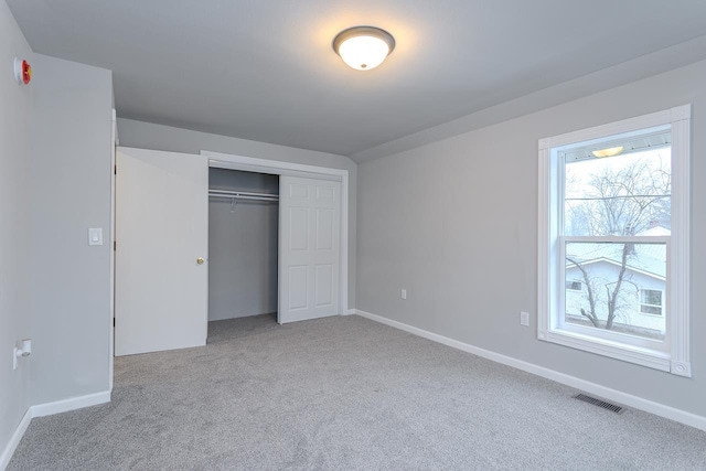 unfurnished bedroom with carpet floors, baseboards, visible vents, and a closet