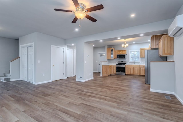 kitchen featuring open floor plan, light countertops, appliances with stainless steel finishes, and a wall mounted AC