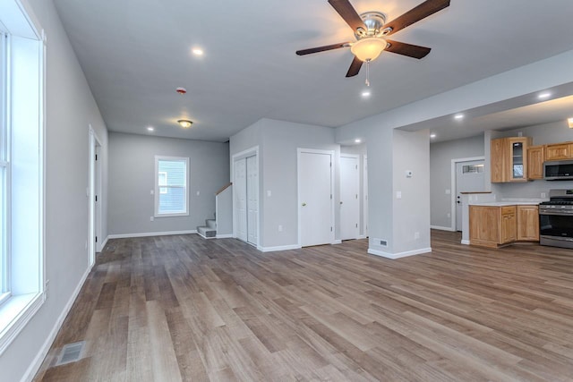 unfurnished living room featuring recessed lighting, wood finished floors, visible vents, baseboards, and stairs