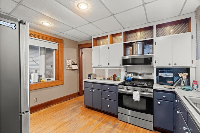 kitchen with white cabinetry, appliances with stainless steel finishes, open shelves, and light countertops