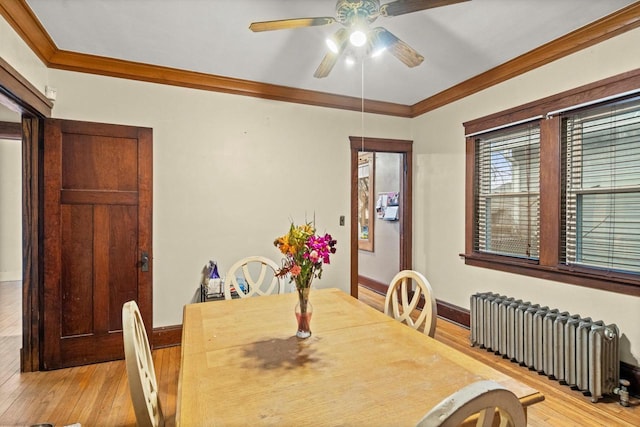 dining area with ornamental molding, radiator heating unit, light wood-style flooring, and baseboards