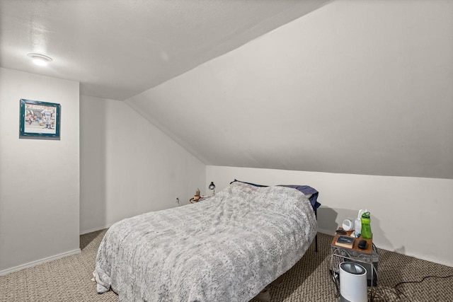 carpeted bedroom with baseboards and vaulted ceiling