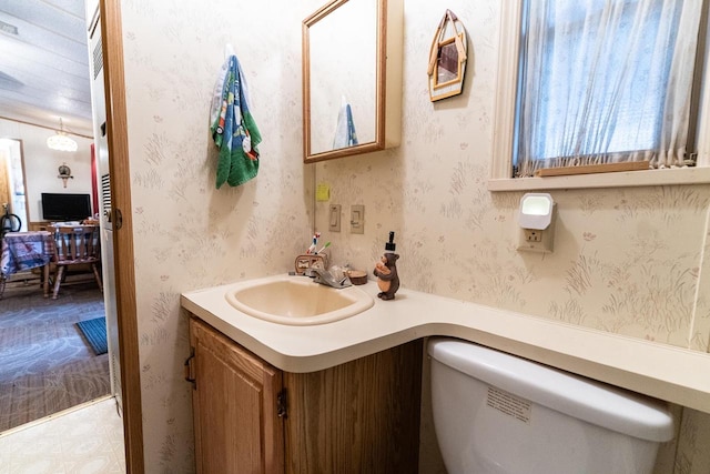 bathroom with wallpapered walls and vanity