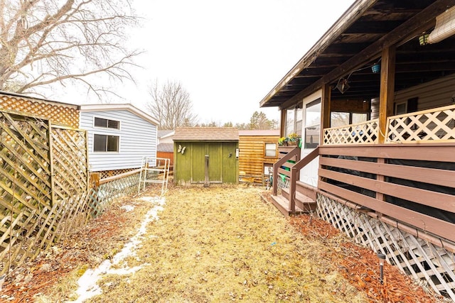 view of yard featuring a storage unit, an outdoor structure, and fence