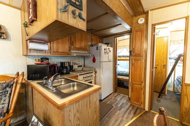 kitchen featuring stainless steel gas stove, freestanding refrigerator, extractor fan, black microwave, and a sink