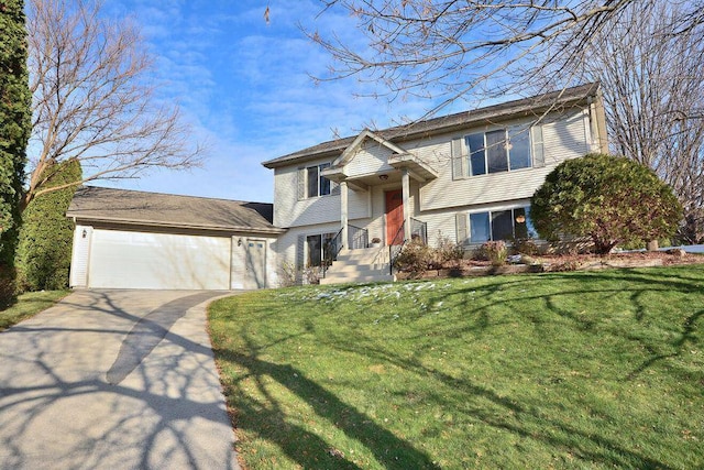 raised ranch with driveway, a front yard, and an attached garage