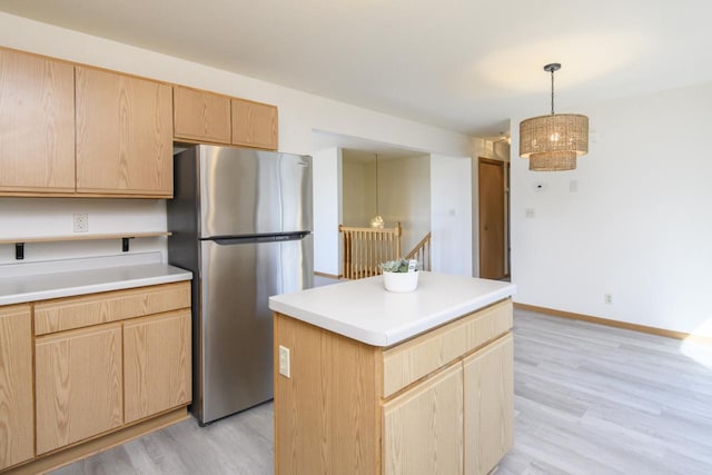 kitchen with light brown cabinetry, light wood-style flooring, light countertops, and freestanding refrigerator