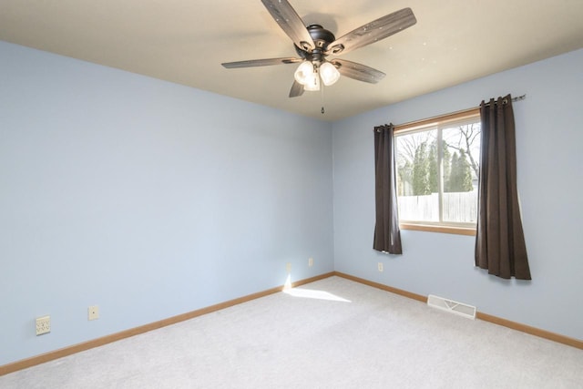 carpeted empty room with visible vents, baseboards, and a ceiling fan