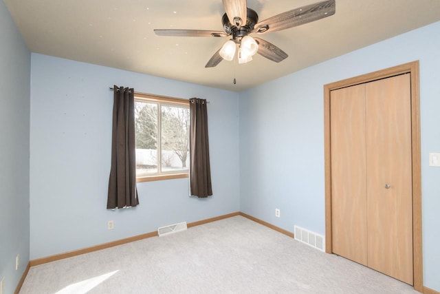 unfurnished bedroom with a closet, visible vents, baseboards, and carpet floors