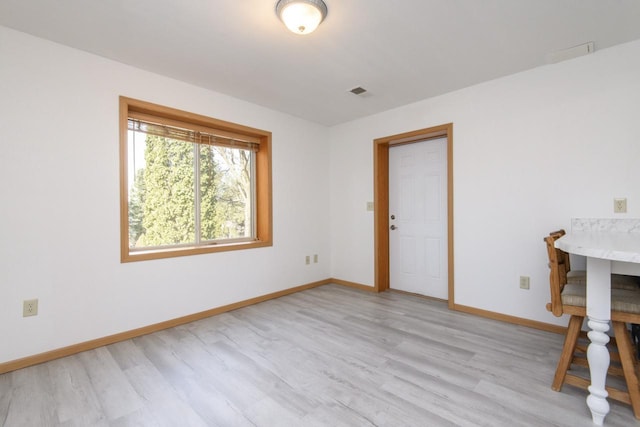 unfurnished room featuring visible vents, light wood-style flooring, and baseboards