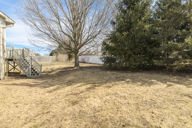 view of yard featuring stairs and fence