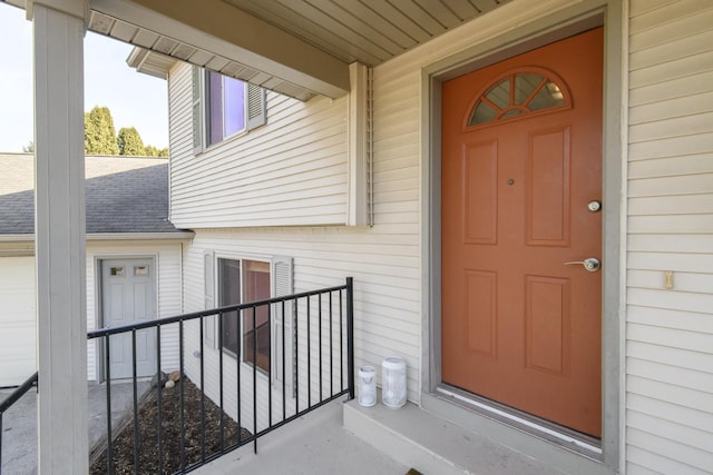 property entrance with a shingled roof