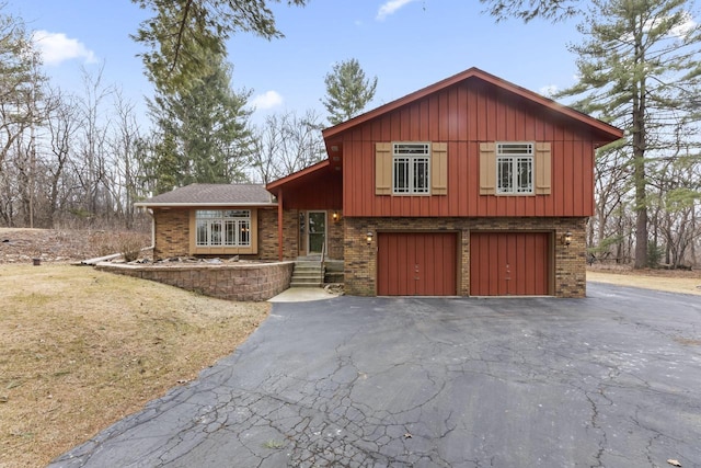 split level home featuring brick siding, driveway, and board and batten siding