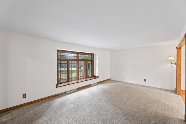 carpeted spare room with visible vents and baseboards