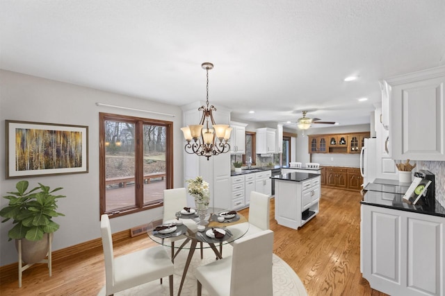 dining area featuring ceiling fan with notable chandelier, recessed lighting, light wood-type flooring, and baseboards