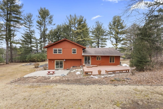 back of house with a deck and a patio