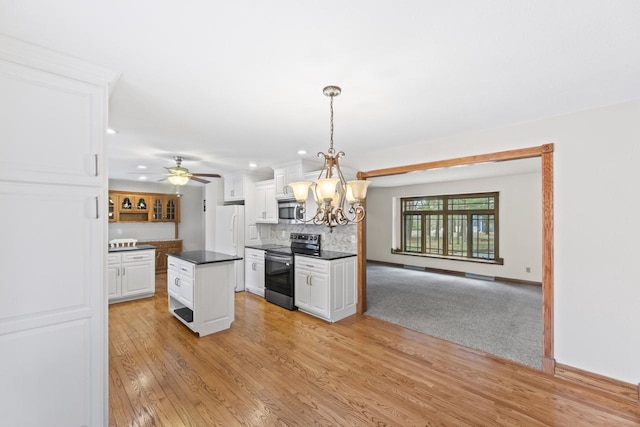 kitchen featuring dark countertops, backsplash, appliances with stainless steel finishes, light wood-style floors, and white cabinets