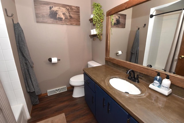 bathroom featuring visible vents, toilet, vanity, wood finished floors, and baseboards