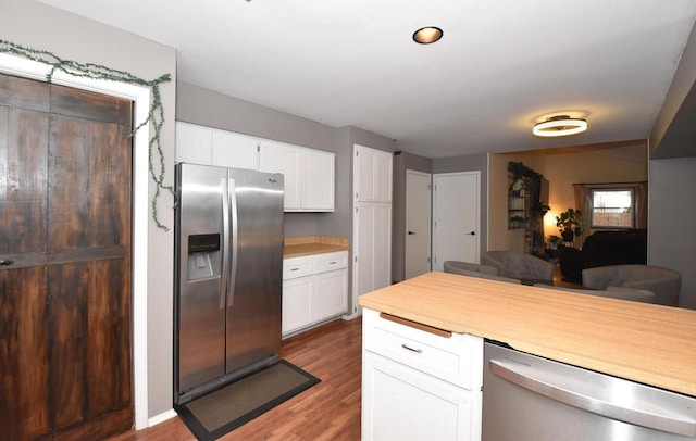 kitchen with appliances with stainless steel finishes, white cabinets, light countertops, and wood finished floors