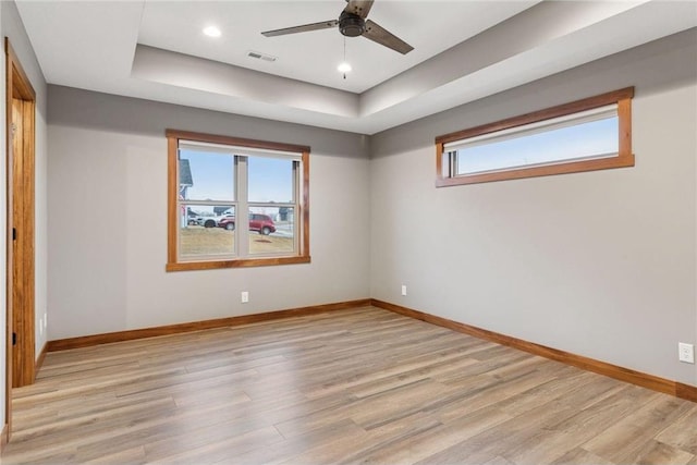 497 Westwood Dr, River Falls, WI 54022 - empty room with light wood-type flooring, a raised ceiling, visible vents, and baseboards