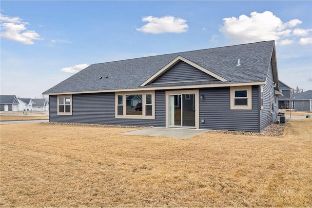 497 Westwood Dr, River Falls, WI 54022 - back of property with a yard, roof with shingles, a patio, and central air condition unit