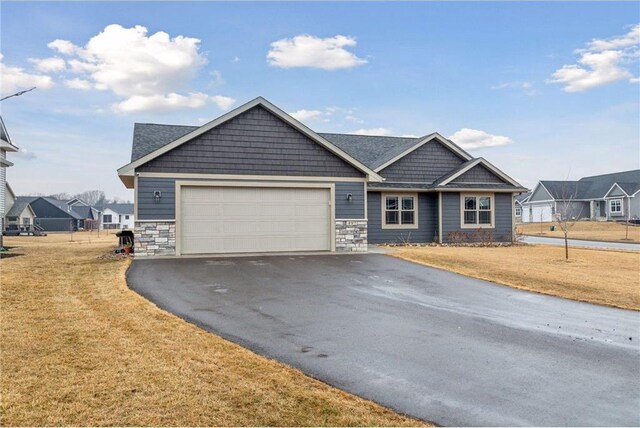 497 Westwood Dr, River Falls, WI 54022 - craftsman-style home with a garage, stone siding, a front yard, and driveway